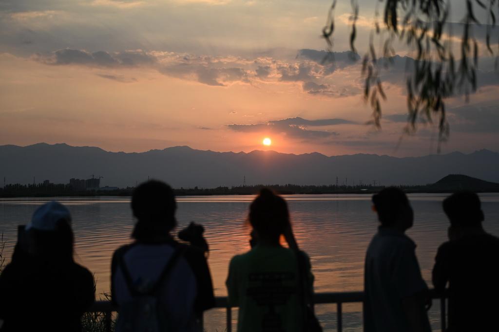 游客在宁夏银川览山公园观赏贺兰山日落（2024年7月10日摄）。新华社记者 毛竹 摄