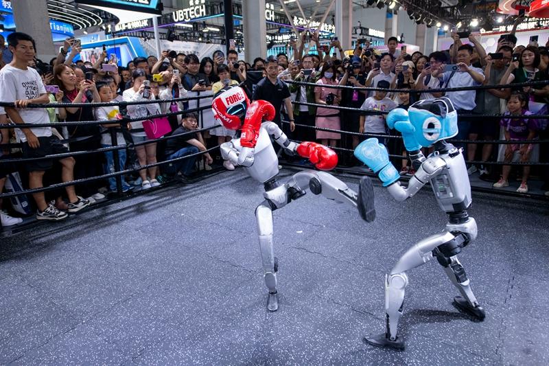 在2025世界机器人大会现场，人形机器人格斗比赛吸引众多参观者驻足观看。人民网记者 翁奇羽摄