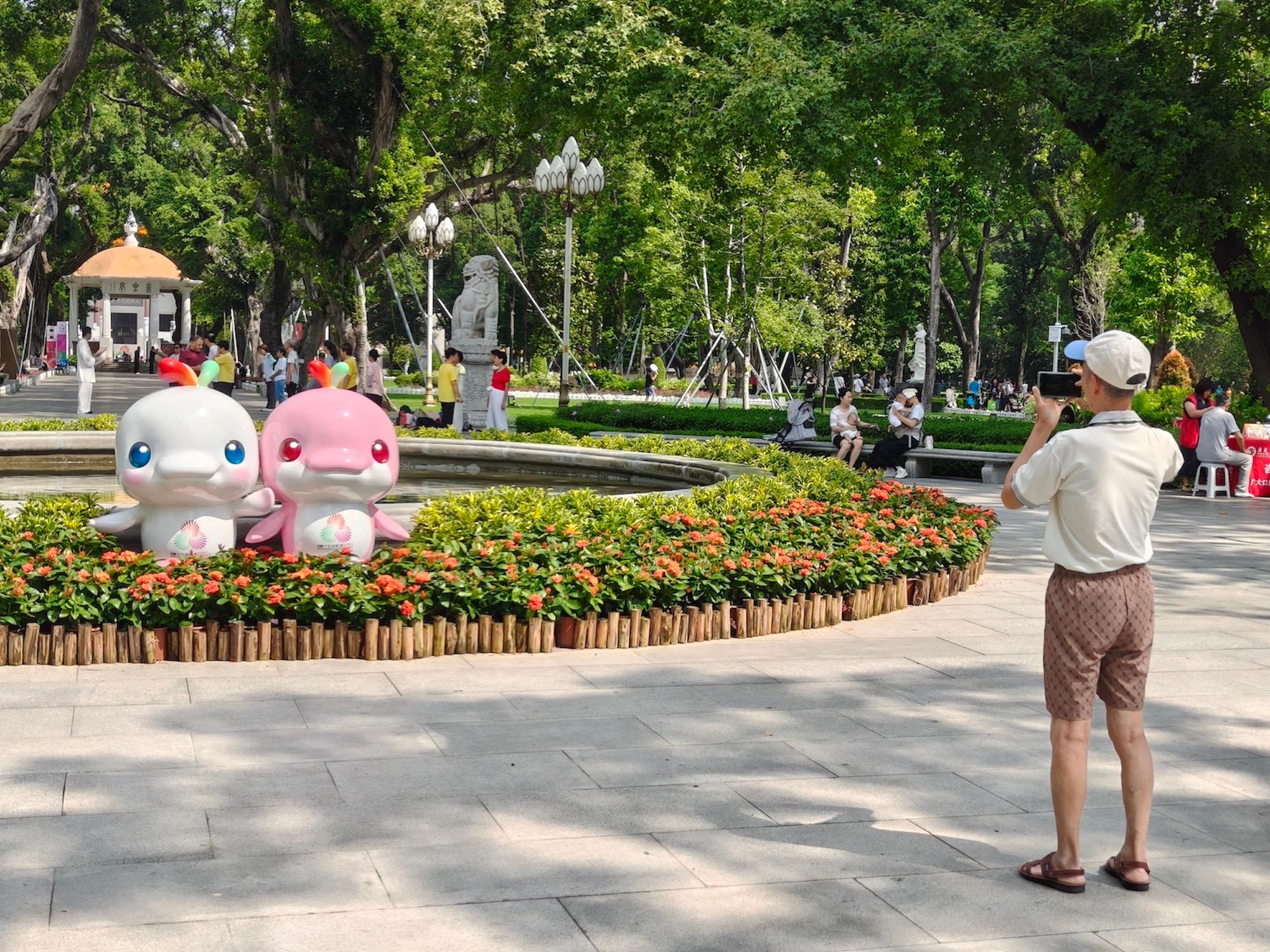 10月10日，游客在人民公园的十五运会吉祥物前摄影，对吉祥物造型充满喜爱。实习生 刘玄摄