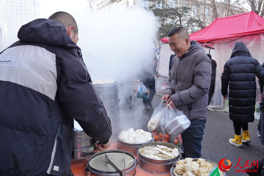 顾客在美食摊位前购买刚出锅的包子。人民网记者 李洋摄